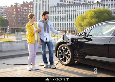 EV-Laden mit Paar Stockfoto
