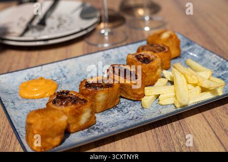 Traditioneller spanischer rabo de toro, paniert und in Scheiben geschnittener Ochsenschwanz, serviert auf Teller, authentische andalusische Küche aus Südspanien, Andalusien Stockfoto