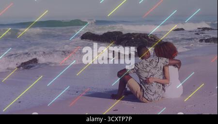 Sitzendes Paar mit Blumenhemd und Sommerkleid am Strand, Wellen krachen auf Felsen, Pastellüberzug Stockfoto