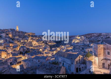 Dämmerung über Matera, Basilicata, Italien, mit einem klaren Himmel und der historischen Sassi di Matera im Abendlicht. Die Steinhäuser und die verwinkelte Gasse Stockfoto