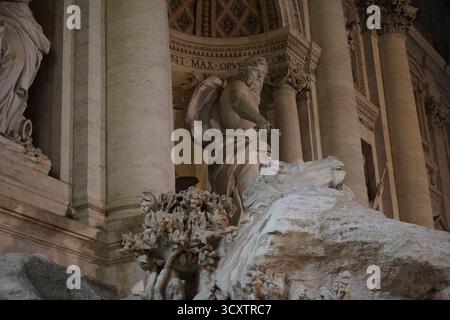 Dramatische Nachtaufnahme der herrlichen Fassade des Trevi-Brunnens in Rom, die die barocke Architektur und Skulpturen hervorhebt. Stockfoto