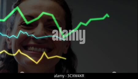 Zeigt Frau in dunklem Top, die links im Büro lächelt, mit grünen, blauen, gelben Trendlinien Stockfoto