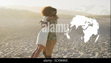 Umarmtes Paar, das sich umarmt auf der Sanddüne unter goldenem Licht, mit gepunkteter Karte und weißem Globus Stockfoto