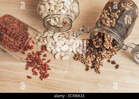 Sanft geröstete Mandeln, hydrierte goldene Rosinen, frisch gekrackte Walnüsse und Goji-Beeren auf Granit Stockfoto