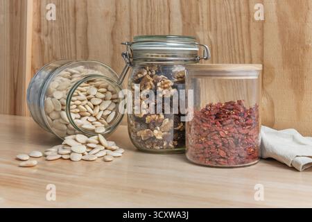 Gewürzte geröstete Mandeln, hydrierte goldene Rosinen, frisch geknackte Walnüsse und Goji-Beeren auf schwarzem Schiefer Stockfoto