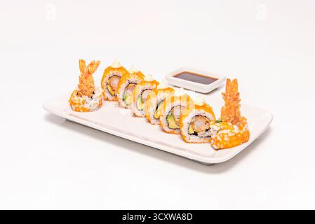 Garnelen- und Mangouramaki mit scharfer Mangohauce, auf einer grob strukturierten Porzellanplatte Stockfoto