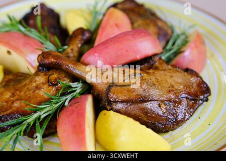 Schritt für Schritt kochen von Entenschenkeln mit Äpfeln. Die junge Frau schneidet Äpfel in Scheiben, legt sie auf einem Tablett mit Ente an, bereitet sie zu und brät sie, wobei sie den vollen hausgemachten Prozess bis zum letzten Gericht zeigt. Stockfoto