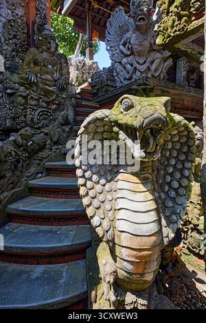 Aufwändig geschnitzte Steinstatue von Naga, halbgöttlicher Kreatur in der indischen Mythologie, im Puri Langon Tempel in Ubud, Gianyar, Bali, Indonesien. Stockfoto