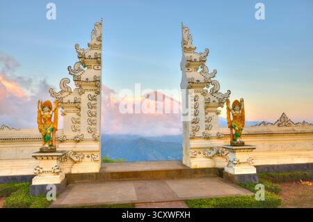 Blick auf den Vulkan Mount Agung durch candi Bentar (geteiltes Tor) am Lahangan Sweet Aussichtspunkt am Morgen bei Sonnenaufgang. Karangasem, Bali, Indonesien. Stockfoto