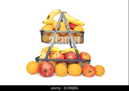 Bunte Früchte sind in einem Drahtkorb angeordnet. Der obere Korb enthält Bananen, Äpfel, Granatäpfel und Orangen und sorgt so für einen lebendigen und einladenden Blick Stockfoto