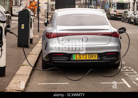 LONDON, 26. SEPTEMBER 2025: Mercedes EQS 450+ Elektroauto lädt auf einer Stadtstraße in London auf Stockfoto