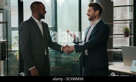 Zwei Männer Business Team multiethnische Geschäftsleute Handschütteln sprechen im Büro Teamarbeit Partnerschaft multinationale Zusammenarbeit Kollegen schütteln die Hand Stockfoto