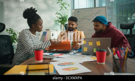 Drei Geschäftsmitarbeiter Teambesprechung Besprechungsbüro diskutieren mit Laptop die Ergebnisse von Dokumenten und lösen das Problem des Finanzbudgets des Unternehmens. Lächelnd Stockfoto