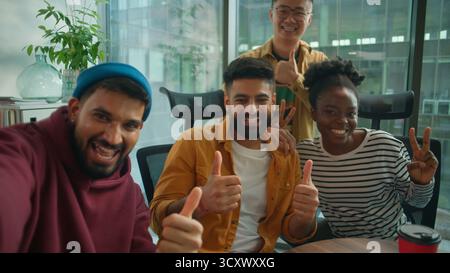Blickwinkel von Telefon-Webkamera vier Diversity-Kollegen informelle Unternehmensgruppe von Managern, die Selfie-Fotos machen und Spaß im Büro haben Stockfoto