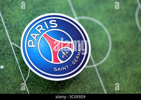 KIEW, UKRAINE - 23. FEBRUAR 2025 das Abzeichen des FC Paris Saint Germain liegt auf dem Hintergrund des Fußballfeldes Stockfoto
