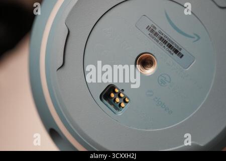 London, Großbritannien – 2025.10.16 – detailliertes Makro der Basis eines intelligenten Lautsprechers von Amazon Echo Alexa mit Zigbee-Anschlussstiften, serielles Etikett, an Stockfoto