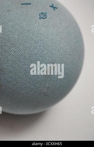 London, Großbritannien – 2025.10.16 – Nahaufnahme eines blauen Amazon Echo Alexa Smart Speakers mit Mesh-Textur und Steuertasten gegen einen Whir Stockfoto