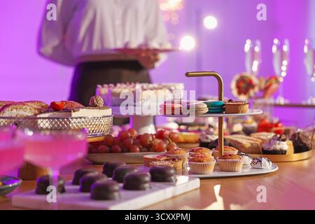 Verschiedene leckere Desserts, Getränke am Buffet und Kellner, selektiver Fokus Stockfoto