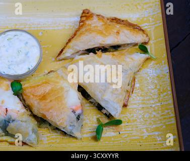 Lachs-Käse-Quiche mit Kräutern, frisch zum Frühstück gebacken, auf einem Schneidebrett geschnitten. Hochwertige Fotos Stockfoto
