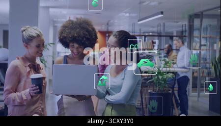 Zusammenarbeit mit Kollegen, die Daten auf silbernen Laptops in modernen Büros prüfen, mit Nachhaltigkeitssymbolen Stockfoto