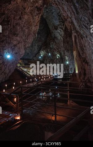 Das Innere einer Höhle mit einem Weg, der von kleinen Lichtern beleuchtet wird. Stockfoto