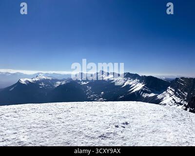 Schneebedeckte Berggipfel unter dem klaren blauen Himmel Stockfoto