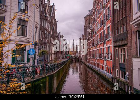 Ein malerischer Kanal in Amsterdam, gesäumt von traditionellen niederländischen Gebäuden mit hohen, schmalen Fassaden und großen Fenstern. Stockfoto