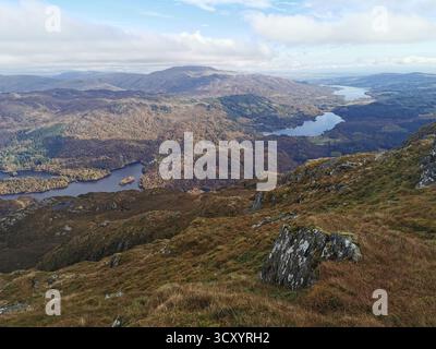Panoramablick vom Ben Venacher Gipfel über Loch Venacher, Loch Achray und Loch Katrine im schottischen Trossachs National Park – malerische Highlands-Landschaft Stockfoto