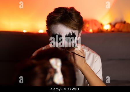 Die Person auf dem Bild malt eine kleine Figur, vielleicht ein Halloween Stockfoto