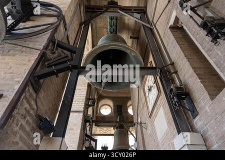 Das Innere der Kathedrale von Sevilla, Spanien, zeigt einen Blick aus nächster Nähe auf majestätische historische Glocken. Gotische Architekturdetails und die einzigartige Atmosphäre eines Stockfoto