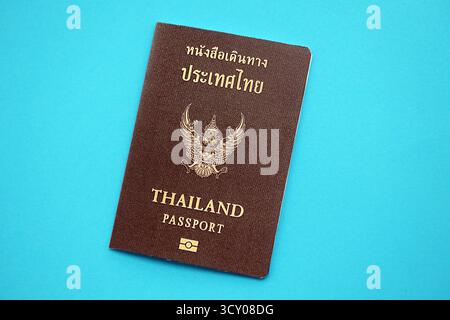 Thailändisches Passbuch auf hellblauem Papierhintergrund Nahaufnahme. Reisedokument auf blauer Oberfläche Stockfoto