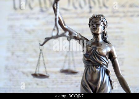 Die Statue der Gerechtigkeit Themis, die Göttin der Gerechtigkeit mit den Augen gegen die US-Verfassung Seite. Urteil und Strafe in den Vereinigten Staaten Stockfoto