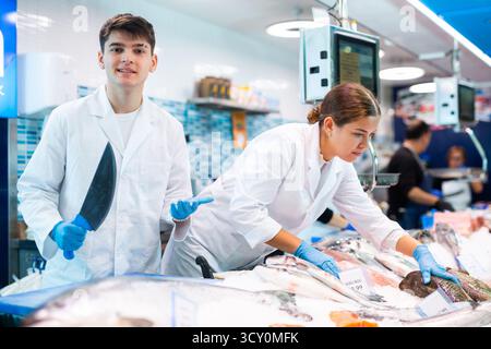 Männlicher Arbeiter, der frischen Fisch für den Verkauf in einem Fischladen zubereitet Stockfoto