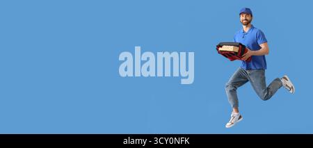 Springender männlicher Kurier mit Pizza auf blauem Hintergrund mit Platz für Text Stockfoto