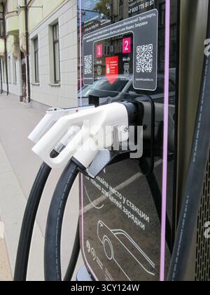 Moskau, Russland, 29. September 2025: Eine detaillierte Nahaufnahme zweier weißer Elektrofahrzeug-Ladeanschlüsse, die an eine moderne Ladestation angeschlossen wurden. Stockfoto