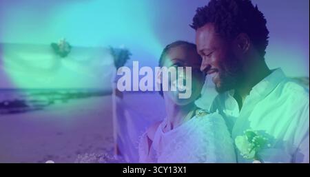 Stehende Braut und Bräutigam mit Blumenstrauß unter dem Hochzeitsbogen am Sandstrand, Boutonniere, Kopierraum Stockfoto