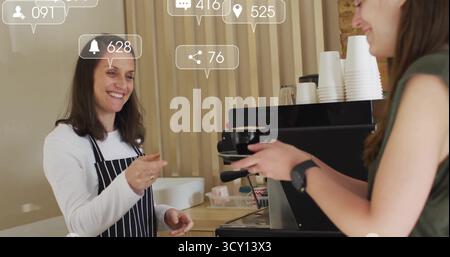 Der Barista wird auf der Schürze serviert und die Kaffeetasse hinter der Theke mit Maschine und Kopierraum an den Gast weitergereicht Stockfoto