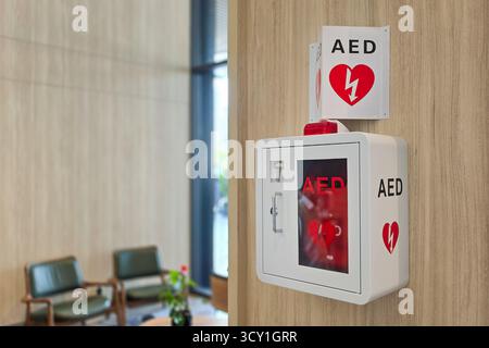 AED oder automatisierter externer Defibrillator, der als erste Hilfe bei Herzinfarkt an der Wand in der Hotellobby installiert ist. Stockfoto