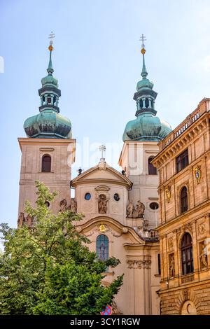 Zwei Türme der Kirche St. Salvator, die an einem sonnigen Sommertag über den umliegenden Gebäuden in der Prager Altstadt in Tschechien ragen. Stockfoto