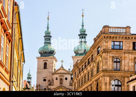 Zwei Türme der Kirche St. Salvator, die an einem sonnigen Sommertag über den umliegenden Gebäuden in der Prager Altstadt in Tschechien ragen. Stockfoto