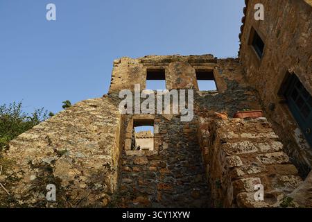 Sanftes Morgenlicht, die Überreste eines alten Steingebäudes, Fensteröffnungen, blauer Himmel, baufällig, Monemvassia, Malvasy, byzantinische Kleinstadt, felsig ist Stockfoto