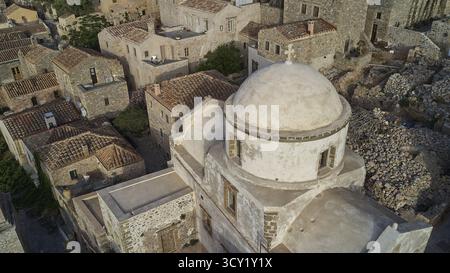 Blick auf die Drohne, historische Kirche mit Kuppel umgeben von einem Dorf, aus der Luft genommen, Monemvasia, Monemvassia, Malvasy, byzantinische Kleinstadt, felsige Insel Stockfoto