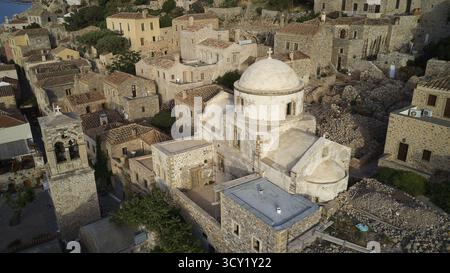 Blick auf die Drohne, aus der Vogelperspektive auf Kirchen und Steinhäuser im traditionellen Dorf mit Vegetation, Monemvasia, Monemvassia, Malvasy, kleine byzantinische Stadt, r Stockfoto