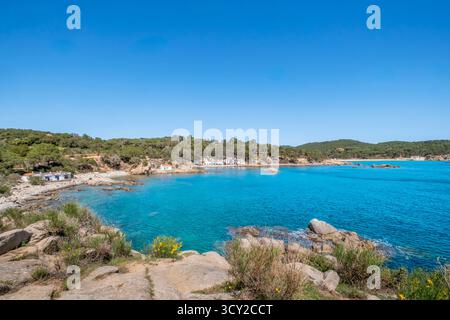 Weite Panoramaaufnahme, die den beeindruckenden Kontrast zwischen dem tiefen türkisfarbenen Wasser und den mit Kiefern bedeckten Hügeln rund um eine malerische Bucht mit sm festlegt Stockfoto