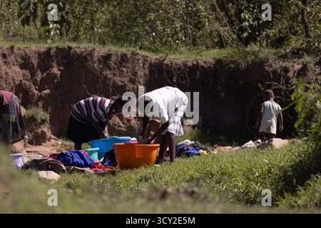 Dorfleben im Dorf Sekenani in der Nähe von Masai Mara, Kenia Frauen waschen Kleidung im Fluss die Bewohner sind Teil des Maasai-Stammes Stockfoto