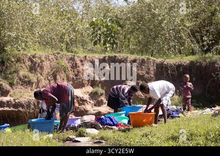Dorfleben im Dorf Sekenani in der Nähe von Masai Mara, Kenia Frauen waschen Kleidung im Fluss die Bewohner sind Teil des Maasai-Stammes Stockfoto