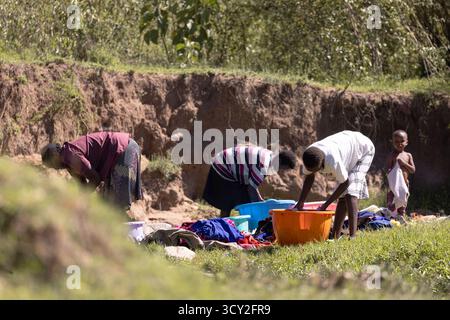 Dorfleben im Dorf Sekenani in der Nähe von Masai Mara, Kenia Frauen waschen Kleidung im Fluss die Bewohner sind Teil des Maasai-Stammes Stockfoto