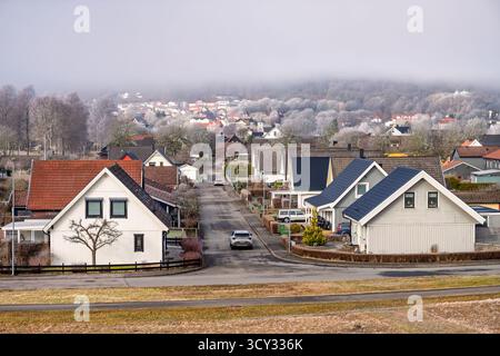 Autofahrt auf einer Straße in einem Wohngebiet mit Einfamilienhäusern an einem frostigen Frühlingstag Stockfoto