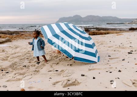 Abwechslungsreiche Familie am Strand bei Sonnenaufgang Stockfoto