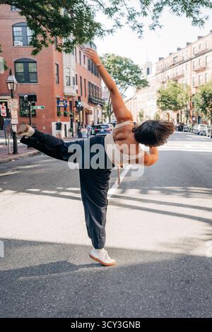 Eine Frau tanzt frei auf einer Straße in boston Stockfoto